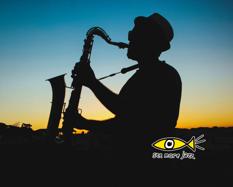 Jazzmusiker mit Hut spielt Saxophon im Sonnenuntergang